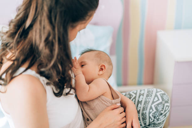 Young mother is breastfeeding her baby. In Vitro Fertilization (IVF). Family of asians.