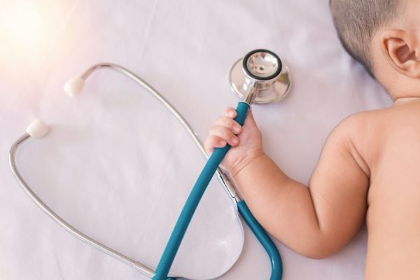 medical instruments stethoscope in hand of newborn baby girl.